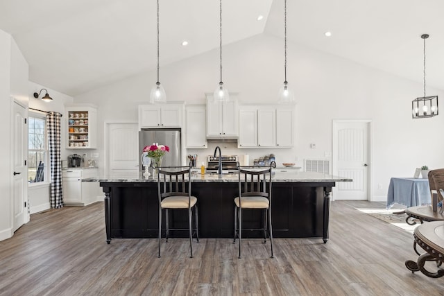 kitchen featuring white cabinets, light wood-style floors, a large island, and stainless steel refrigerator