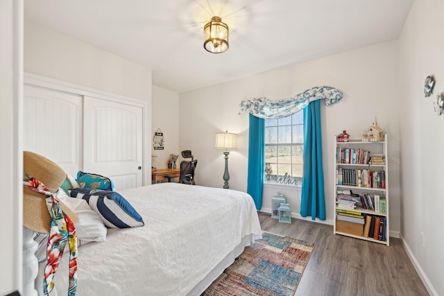 bedroom featuring a closet, baseboards, and wood finished floors