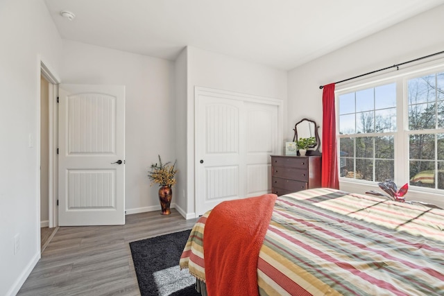 bedroom featuring baseboards, a closet, and wood finished floors