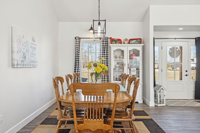 dining space with a chandelier, wood finished floors, and baseboards