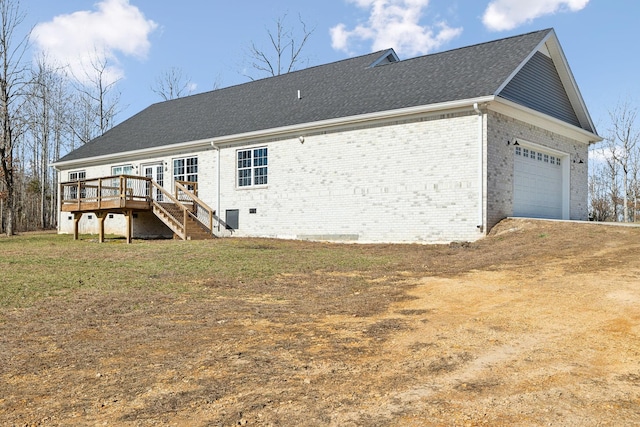 rear view of property with brick siding, an attached garage, crawl space, a deck, and stairs