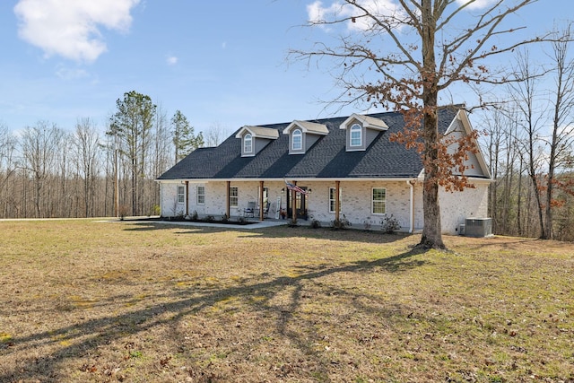 cape cod home with central AC unit, a front lawn, and a shingled roof