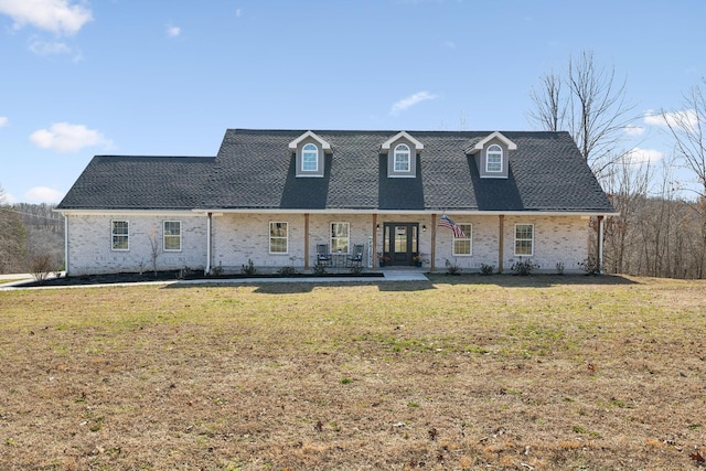 view of front of property with a shingled roof and a front lawn