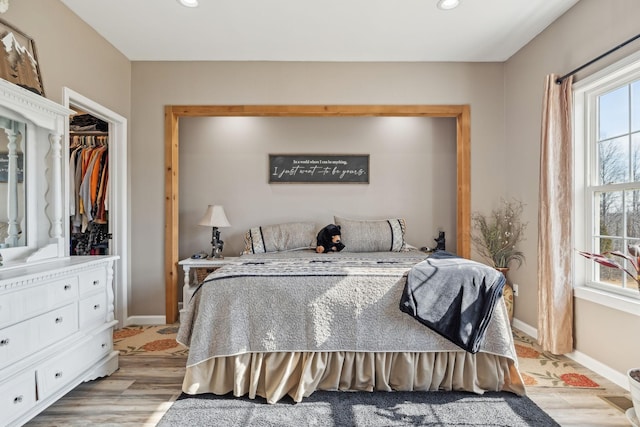 bedroom featuring baseboards, multiple windows, recessed lighting, and light wood-style floors