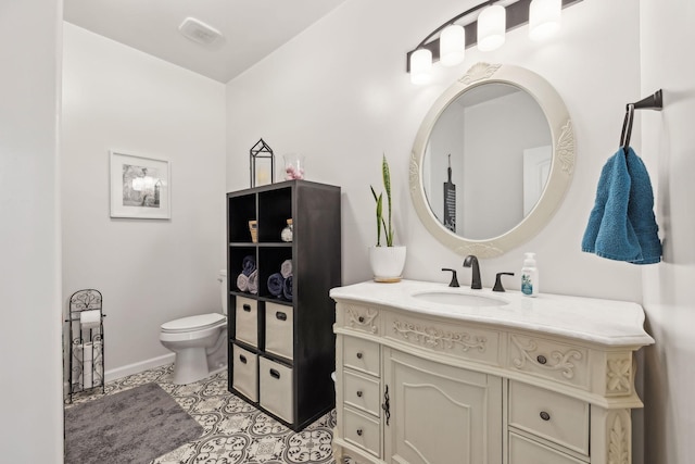 bathroom featuring vanity, tile patterned flooring, toilet, and baseboards