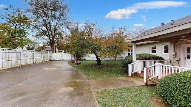 view of yard with ceiling fan, a gate, and fence