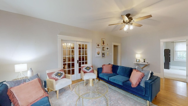 living room with a ceiling fan, french doors, baseboards, and wood finished floors