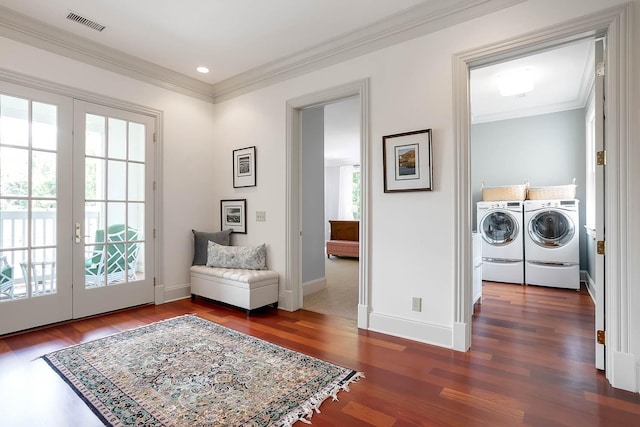 entryway with dark wood-style floors, separate washer and dryer, visible vents, and crown molding