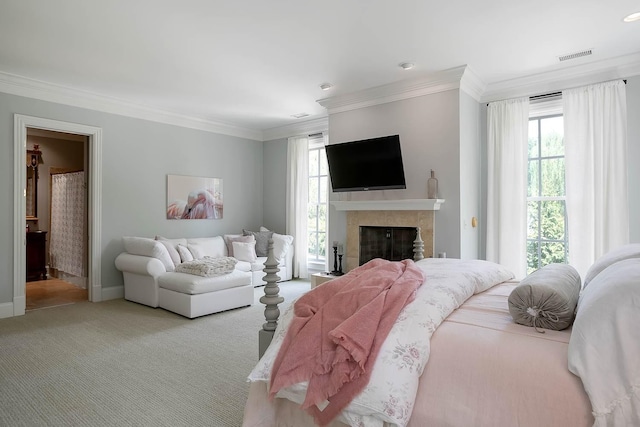 carpeted bedroom with multiple windows, a fireplace, visible vents, and crown molding