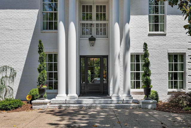 doorway to property featuring brick siding