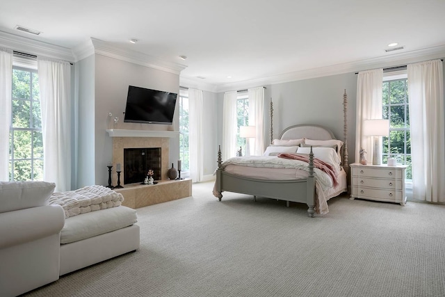 carpeted bedroom featuring ornamental molding, visible vents, and a fireplace