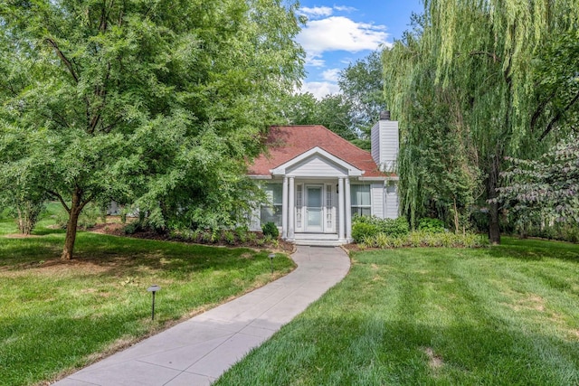 exterior space featuring a chimney and a front yard