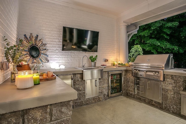 view of patio with wine cooler, an outdoor kitchen, a sink, and area for grilling