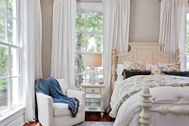 bedroom with multiple windows and wood finished floors