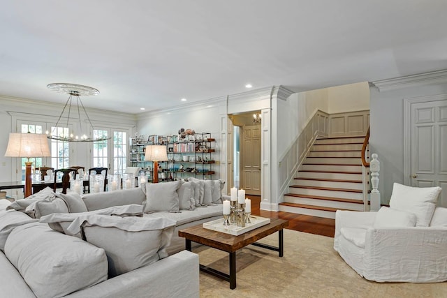 living area featuring stairs, a chandelier, and crown molding