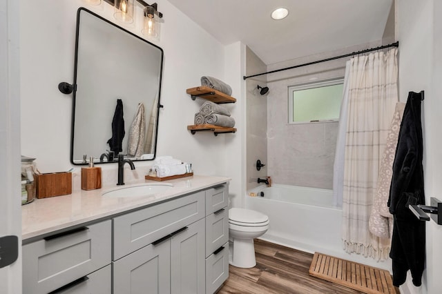 bathroom featuring visible vents, toilet, shower / bath combo with shower curtain, vanity, and wood finished floors