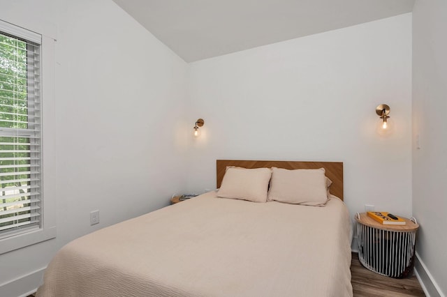 bedroom with baseboards and wood finished floors