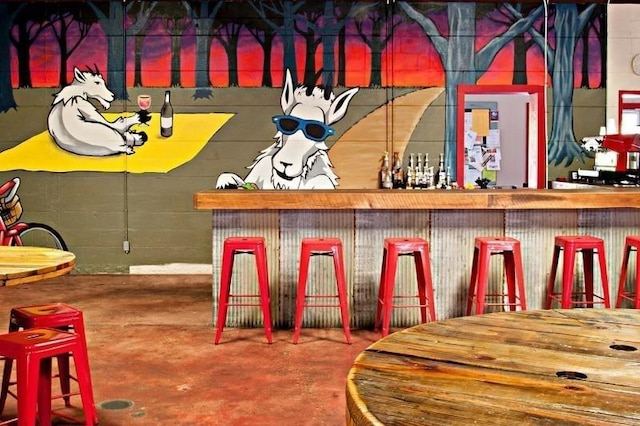 bar featuring a dry bar and concrete floors