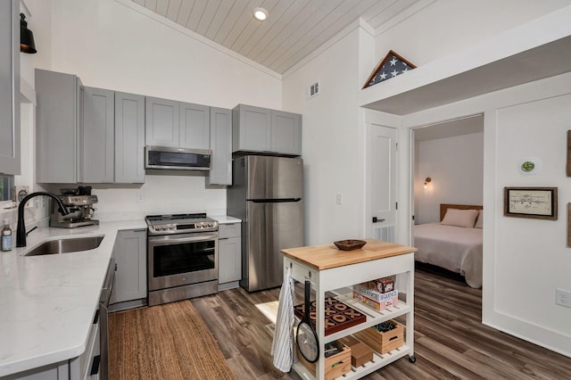 kitchen with stainless steel appliances, a sink, visible vents, gray cabinets, and crown molding