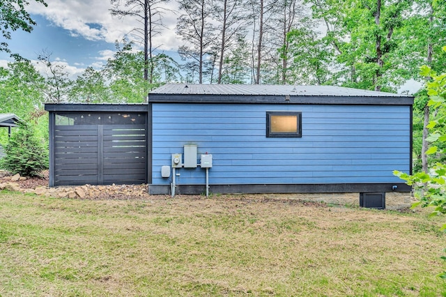 exterior space featuring metal roof and a yard