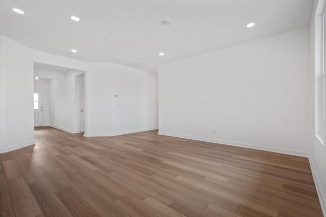 spare room featuring baseboards, light wood-type flooring, and recessed lighting