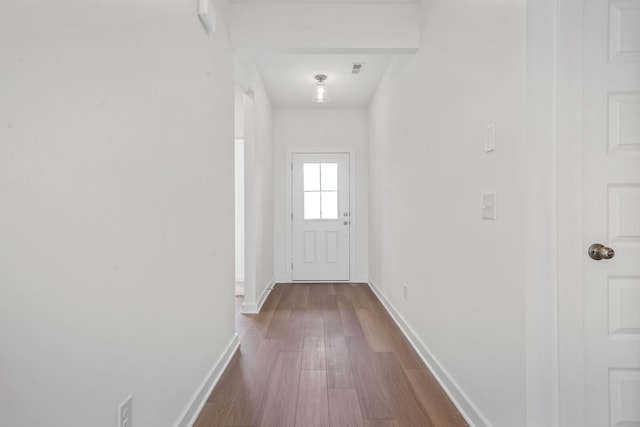 doorway to outside with baseboards and dark wood-type flooring