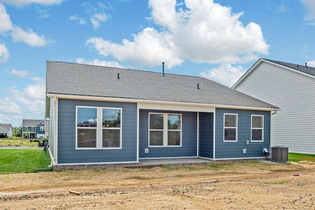 rear view of house with a shingled roof, a patio, and central AC unit