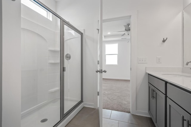 bathroom with vanity, baseboards, a ceiling fan, tile patterned floors, and a stall shower