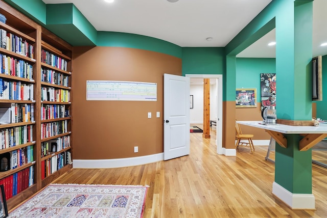 living area with baseboards and wood finished floors