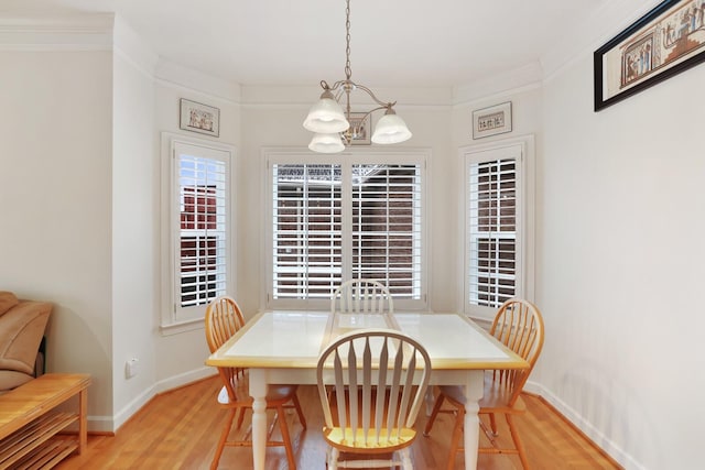 dining space featuring ornamental molding, light wood-type flooring, and baseboards