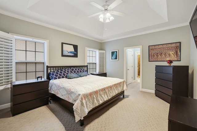 bedroom with baseboards, a tray ceiling, ornamental molding, and light colored carpet