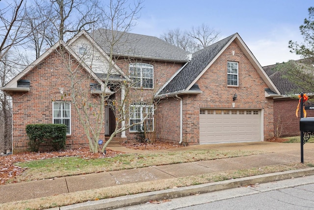 traditional-style house with a garage, driveway, brick siding, and a shingled roof