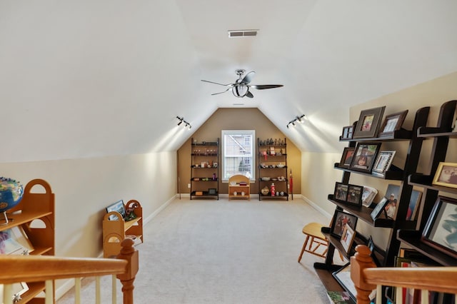 living area featuring lofted ceiling, visible vents, a ceiling fan, carpet flooring, and baseboards