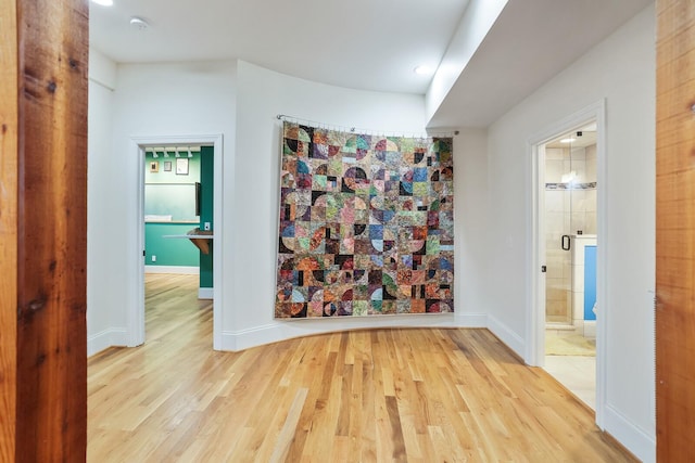 corridor featuring wood finished floors and baseboards