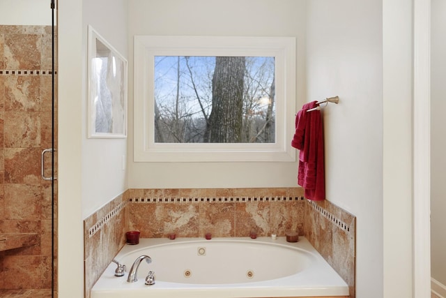 bathroom with a stall shower and a tub with jets