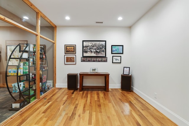 unfurnished office featuring recessed lighting, wood finished floors, visible vents, and baseboards