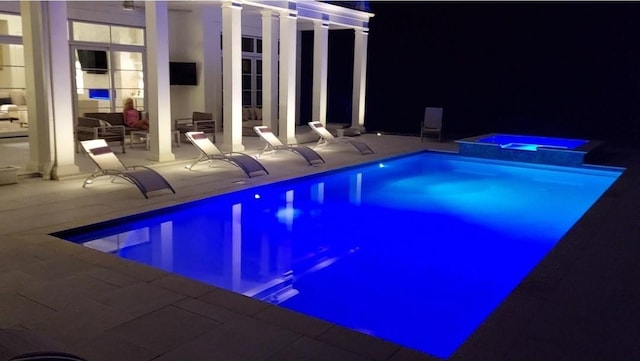 view of pool with a patio area and a pool with connected hot tub