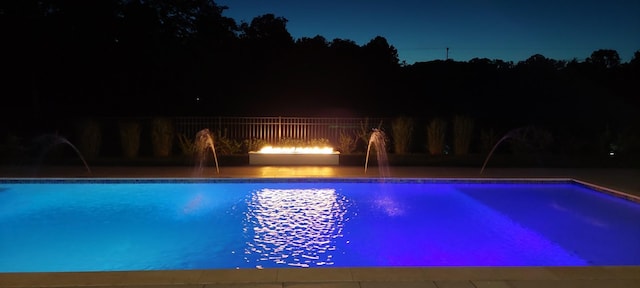 pool at night featuring an outdoor pool