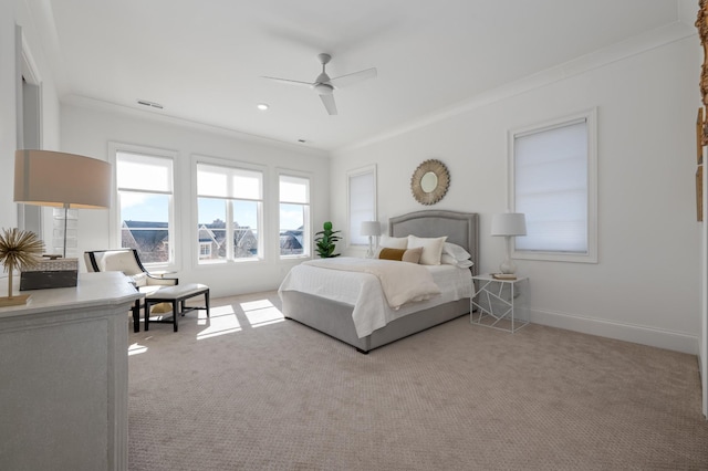 carpeted bedroom with ornamental molding, baseboards, and a ceiling fan