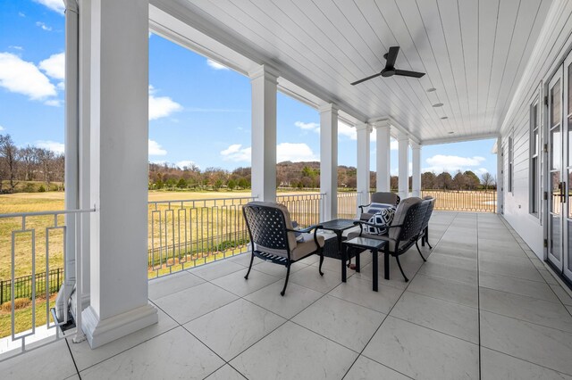 sunroom / solarium featuring a ceiling fan, a wealth of natural light, and wooden ceiling