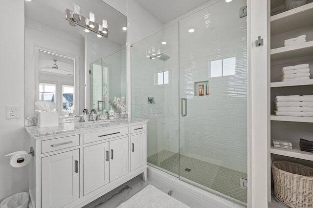 bathroom with marble finish floor, a shower stall, ceiling fan, and vanity