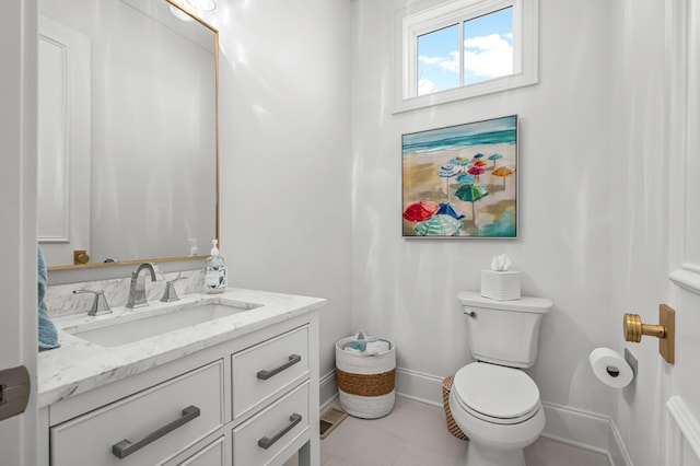 bathroom with toilet, tile patterned flooring, baseboards, and vanity