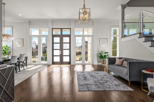 entryway with stairway, ornamental molding, wood finished floors, french doors, and a notable chandelier