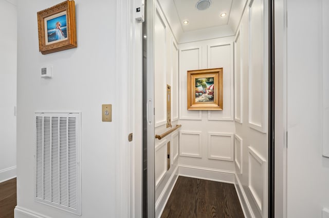 corridor featuring visible vents, elevator, dark wood-style flooring, a decorative wall, and recessed lighting