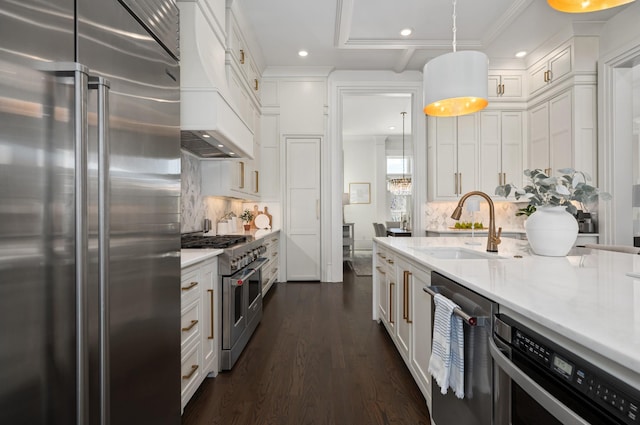 kitchen featuring premium range hood, dark wood-type flooring, a sink, high end appliances, and pendant lighting