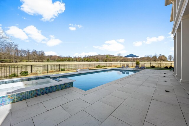 view of pool featuring a patio, a fenced backyard, and a pool with connected hot tub