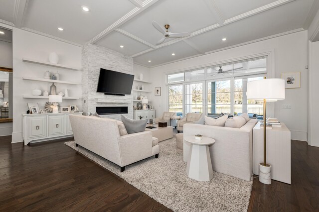 living room featuring built in features, a fireplace, a ceiling fan, and dark wood-style flooring