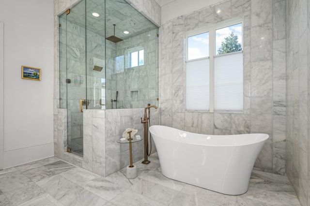 bathroom with a stall shower, marble finish floor, a freestanding bath, and tile walls