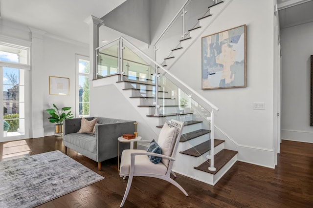 staircase with crown molding, baseboards, and wood finished floors