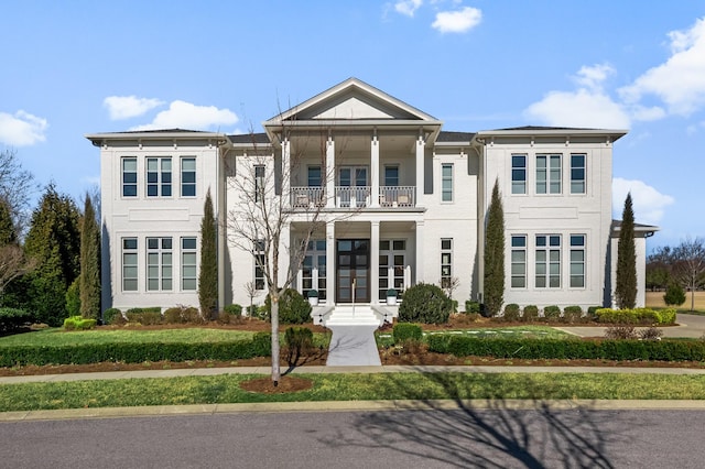 greek revival inspired property with a balcony and french doors